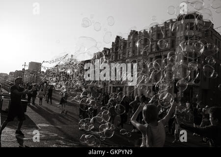 Bubble uomo creando bolle nel cielo in Brighton a una folla di curiosi Foto Stock