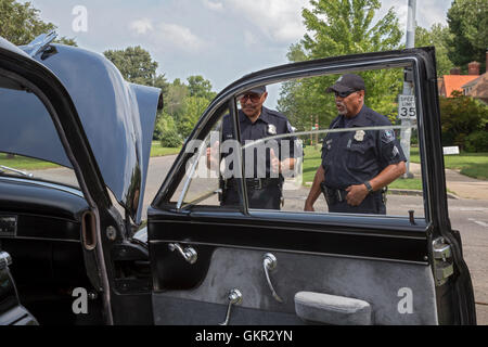 Detroit, Michigan - gruppi di vicinato tenere un estate street fair. Riserve ufficiali della polizia di esaminare un 1949 Cadillac sul display. Foto Stock