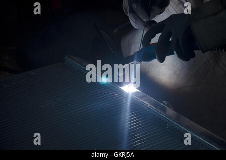 I thailandesi utilizzano l'elettricità di saldatura per fissare e saldare il radiatore di auto in garage locale a Nonthaburi, Tailandia Foto Stock