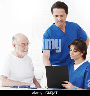 Felice paziente senior e i medici in ospedale Foto Stock