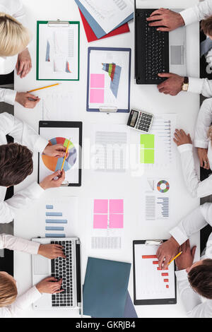 La gente di affari discutendo le tabelle e grafici che mostrano i risultati del loro lavoro di squadra di successo Foto Stock