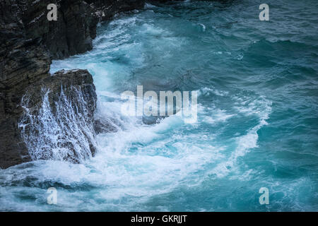 Mare oscilla attorno e sopra rocce sulla North Cornwall coast. Foto Stock