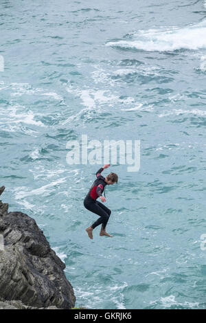 Un adolescente tombstoning off a strapiombo sul promontorio in Newquay, Cornwall. Foto Stock