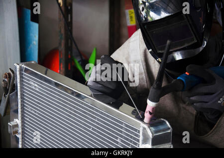 I thailandesi utilizzano l'elettricità di saldatura per fissare e saldare il radiatore di auto in garage locale il 7 luglio 2016 a Nonthaburi Thailandia Foto Stock