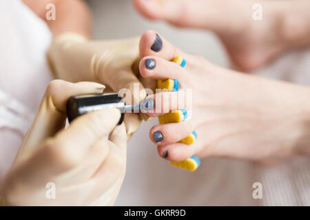 Pedicurist l'applicazione di smalto per unghie, close up foto Foto Stock