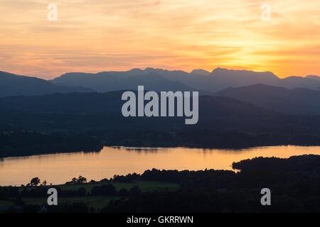 Tramonto su Windermere verso il vecchio di Coniston e le pike di Langdale, da Orrest Head, Windermere, Cumbria Foto Stock