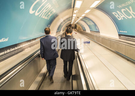 Pendolari,passando,poster,AD,affissioni, sul marciapiede di scendere alla stazione della metropolitana di Bank per linea Bank-Waterloo. Londra, finanziario, district,la città, Foto Stock