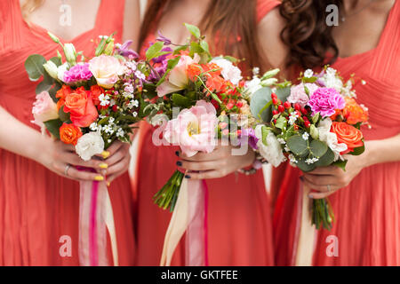 Bridesmaids detiene mazzi di fiori in mano. Foto Stock