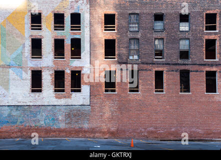 Il vecchio edificio abbandonato nel centro di Detroit. Facciata in mattoni e in parte con una pittura colorata. Vetri rotti. Foto Stock