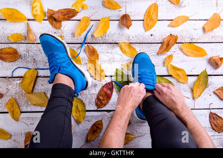 Irriconoscibile runner in calzature sportive la legatura lacci delle scarpe. In autunno le Foto Stock