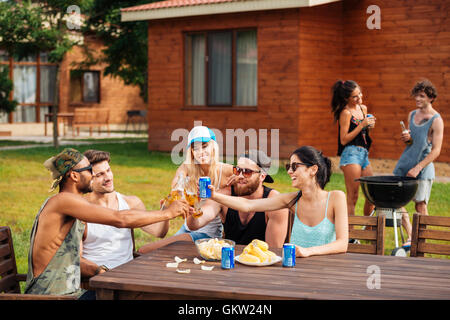 Un gruppo di giovani felici hanno celebrando e bere all'aperto Foto Stock