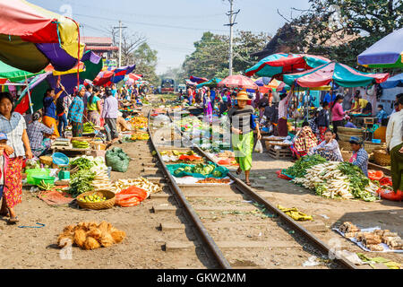 Avvicinando il treno che passa attraverso il tradizionale Ya Zay Railway Bazaar, un mercato all'aperto tenuto su binari ferroviari, Mandalay Myanmar (Birmania) Foto Stock