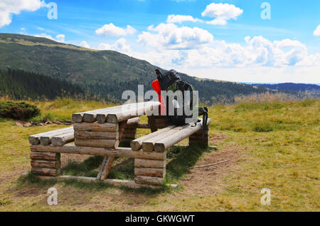 Zaino montagna escursionista equipaggiamento su legno Tavolo da campeggio Foto Stock