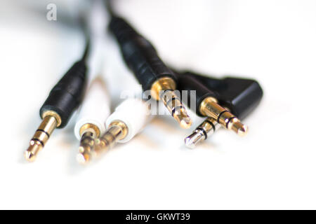Gruppo di cavi audio che mostra il classico spinotto delle cuffie da 3,5 mm Foto Stock