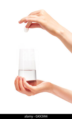 Stretta di mano femmina holding large white round compressa effervescente più trasparente pulita bicchiere con acqua Foto Stock