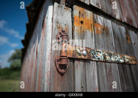 Primo piano di un vecchio arrugginito cerniera su un boathouse Foto Stock