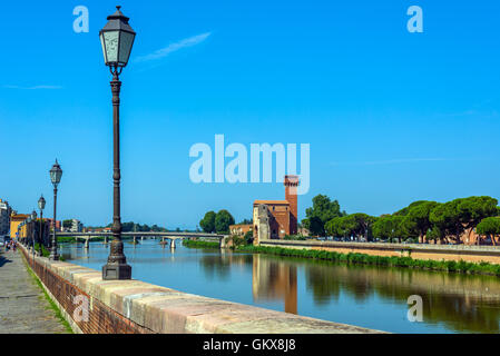 La gente camminare vicino al fiume Arno con Cittadella e Guelfa, torre in background. Pisa, Toscana. L'Italia. Foto Stock