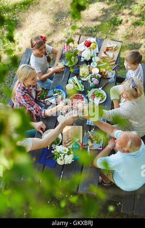 Grande famiglia felice con i ragazzi e nonni avente un sano gustoso pranzo a barbecue all'aperto Foto Stock