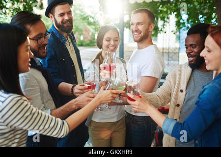 Il tifo amici con wineglasses la tostatura del caffè Foto Stock