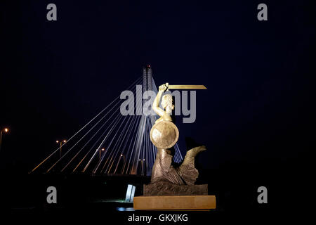 Vista la statua in bronzo di Mermaid di Varsavia Syrenka Warszawska un simbolo di Varsavia, rappresentata sulla città e sul suo stemma realizzato dalla scultrice Louise Nitschowa nel 1939 situato nel punto in cui il ponte Swietokrzyski attraversa il fiume Vistola a Varsavia, Polonia Foto Stock