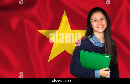 Teen studente sorridente sulla bandiera vietnamita. Concetto di insegnamento e apprendimento delle lingue straniere. Foto Stock