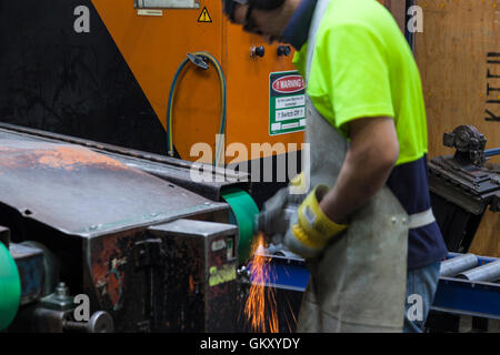 Operai in sicurezza di taglio usura, la rettifica di parti metalliche per ulteriore elaborazione la fabbricazione di componenti per il montaggio Foto Stock