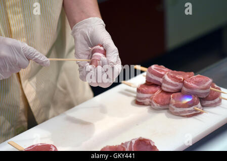 Moenchengladbach, Germania. Il 22 agosto, 2016. Butcher partecipante Maurice Feldbusch prepara medaglioni di maiale durante un appuntamento Premere sull'argomento 'lavoro fattore di mercato commercio: formazione e qualifiche di ingresso' in un ramo di catena di supermercati Real,- SB-Warenhaus in Moenchengladbach, Germania, 22 agosto 2016. Foto: Henning Kaiser/dpa/Alamy Live News Foto Stock