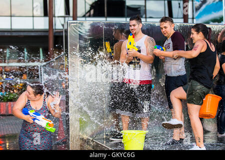 Bristol, Regno Unito. 24 Agosto, 2016. Un massiccio acqua lotta ha avuto luogo a Bristol's Millennium Square questa sera. Decine di persone hanno utilizzato le pistole ad acqua, bottiglie, palloncini e benne per attaccare ogni altro con acqua. Avon e Somerset Vigili del Fuoco sono arrivati con un motore Fire a partecipare. Hanno partecipato anche il Bristol l' ex-eletto sindaco, George Ferguson. L evento è stato organizzato per raccogliere fondi per un senzatetto YMCA hostel. Bristol, Regno Unito. 24 agosto 2016. Credito: Fotografia Redorbital/Alamy Live News Foto Stock