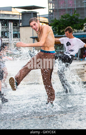 Bristol, Regno Unito. 24 Agosto, 2016. Un massiccio acqua lotta ha avuto luogo a Bristol's Millennium Square questa sera. Decine di persone hanno utilizzato le pistole ad acqua, bottiglie, palloncini e benne per attaccare ogni altro con acqua. Avon e Somerset Vigili del Fuoco sono arrivati con un motore Fire a partecipare. Hanno partecipato anche il Bristol l' ex-eletto sindaco, George Ferguson. L evento è stato organizzato per raccogliere fondi per un senzatetto YMCA hostel. Bristol, Regno Unito. 24 agosto 2016. Credito: Fotografia Redorbital/Alamy Live News Foto Stock