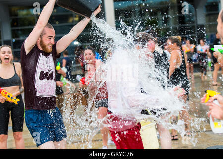 Bristol, Regno Unito. 24 Agosto, 2016. Un massiccio acqua lotta ha avuto luogo a Bristol's Millennium Square questa sera. Decine di persone hanno utilizzato le pistole ad acqua, bottiglie, palloncini e benne per attaccare ogni altro con acqua. Avon e Somerset Vigili del Fuoco sono arrivati con un motore Fire a partecipare. Hanno partecipato anche il Bristol l' ex-eletto sindaco, George Ferguson. L evento è stato organizzato per raccogliere fondi per un senzatetto YMCA hostel. Bristol, Regno Unito. 24 agosto 2016. Credito: Fotografia Redorbital/Alamy Live News Foto Stock