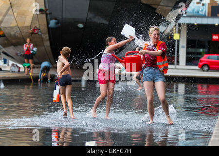 Bristol, Regno Unito. 24 Agosto, 2016. Un massiccio acqua lotta ha avuto luogo a Bristol's Millennium Square questa sera. Decine di persone hanno utilizzato le pistole ad acqua, bottiglie, palloncini e benne per attaccare ogni altro con acqua. Avon e Somerset Vigili del Fuoco sono arrivati con un motore Fire a partecipare. Hanno partecipato anche il Bristol l' ex-eletto sindaco, George Ferguson. L evento è stato organizzato per raccogliere fondi per un senzatetto YMCA hostel. Bristol, Regno Unito. 24 agosto 2016. Credito: Fotografia Redorbital/Alamy Live News Foto Stock