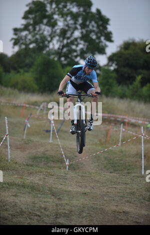 Abingdon Airfield, Dalton caserma, Abingdon, Oxfordshire, Regno Unito. 24 Agosto, 2016. Prendere3 estate ciclocross serie ultima gara. Si tratta di una tecnica veloce gara su erba e terreni ondulati. Questa notte finito in un tramonto infuocato. Regno Unito meteo è stato spettacolare e soleggiato, tuttavia è previsto per ruotare piovoso per il weekend. Questa serie è messo su da prendere3, un triathlon, training, coaching e la progressione di uno specialista. Credito: Sidney Bruere/Alamy Live News Foto Stock