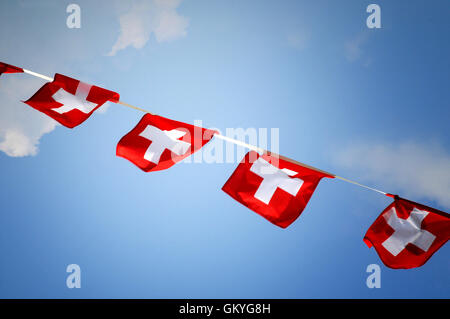 Riga di colorati di rosso bunting con la nazionale svizzera di bandiera nel vento Foto Stock