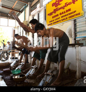 Un team di uomini birmani beat oro a re Galon Workshop a Mandalay, Myanmar (Birmania). Foto Stock