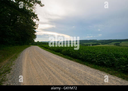 Landscpae di terreni agricoli con la strada attraverso il taglio nel sud della Pennsylvania Foto Stock