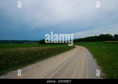 Landscpae di terreni agricoli con la strada attraverso il taglio nel sud della Pennsylvania Foto Stock