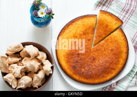 Vista superiore: brown meringhe e manna torta di semola su bianco tavolo in legno Foto Stock