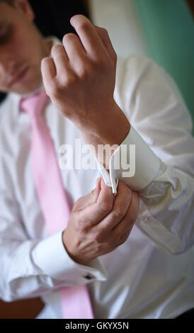 Uomo in camicia bianca e rosa abito cravatta gemelli Foto Stock