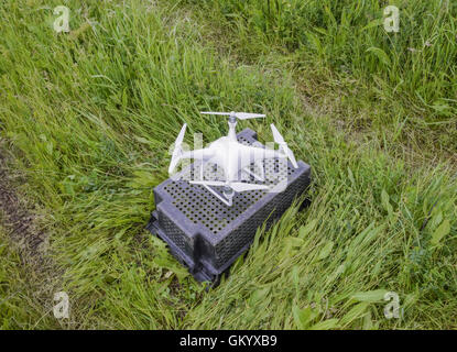 Quadrocopters su una scatola di plastica nell'erba. Preparazione quadrocopter a volare. Foto Stock