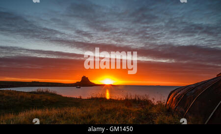 Sunrise sulla bellissima Isola Santa di Lindisfarne con una vista attraverso il porto verso il castello Foto Stock