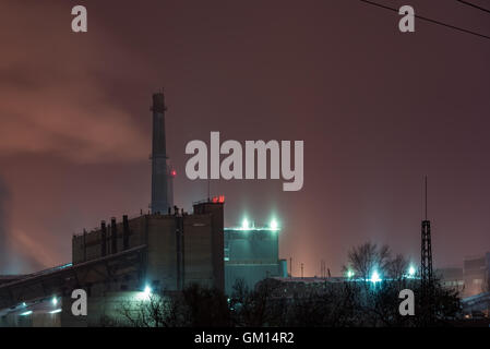 La stazione di potenza con Steam cloud soffiata dal vento in un freddo inverno stellato di notte Foto Stock