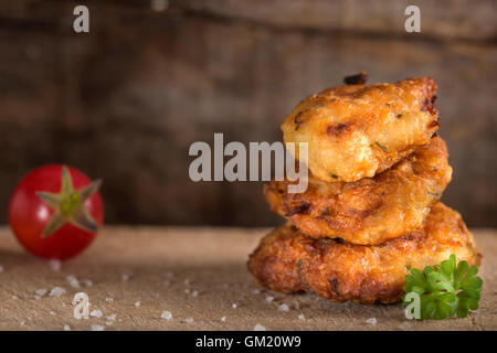 Rumeno polpette di pollo "chiftele' su uno sfondo di legno con prezzemolo e pomodori Foto Stock