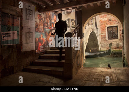 Silhouette maschio attraversando ponte in vicolo, Venezia Italia Foto Stock