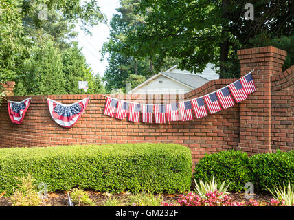 Le bandiere e Bunting sul muro di mattoni in Quartiere Foto Stock