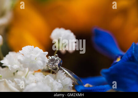 Dettaglio colpo di un anello di fidanzamento in un bouquet di fiori di nozze Foto Stock