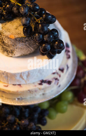 Una pila di formaggi con uve formando una torta ad un ricevimento di nozze Foto Stock