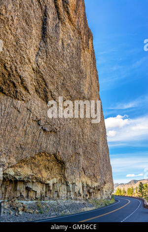 Road passando da una grande scogliera vicino al Tower rientrano nel Parco Nazionale di Yellowstone Foto Stock