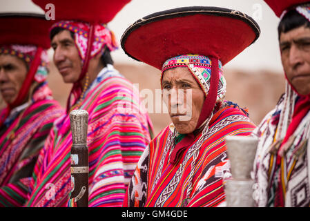 Città indigeni anziani vestiti in intrecci tradizionali si radunano davanti alla chiesa settimanale per la processione di Pisac, Perù. Foto Stock