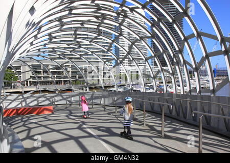 Bambini Un giro in scooter su Webb Bridge a Melbourne in Australia. Foto Stock