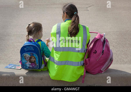 Bambini il caregiver indossando "Les Enfants" ad alta visibilità camicia sulla promendade Blackpool, Lancashire, Regno Unito Foto Stock